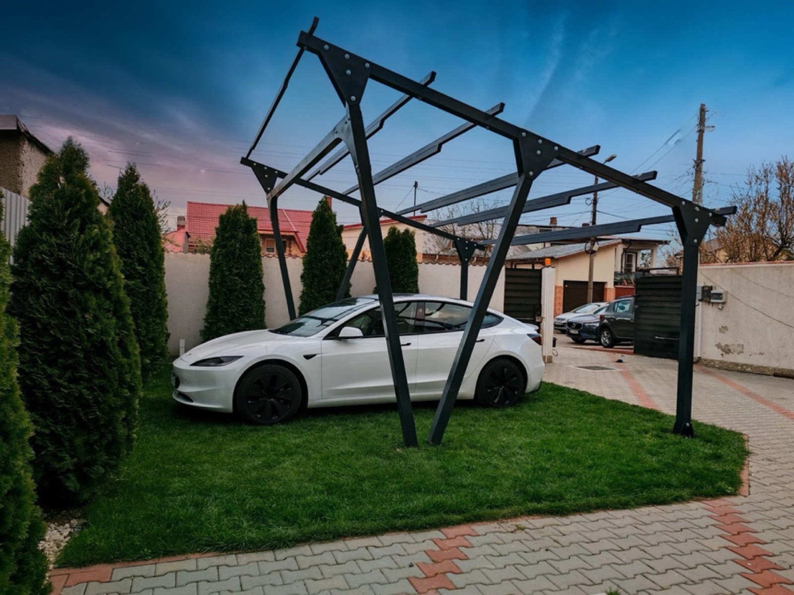 Carport solar HelioPort cu mașină electrică, la apus